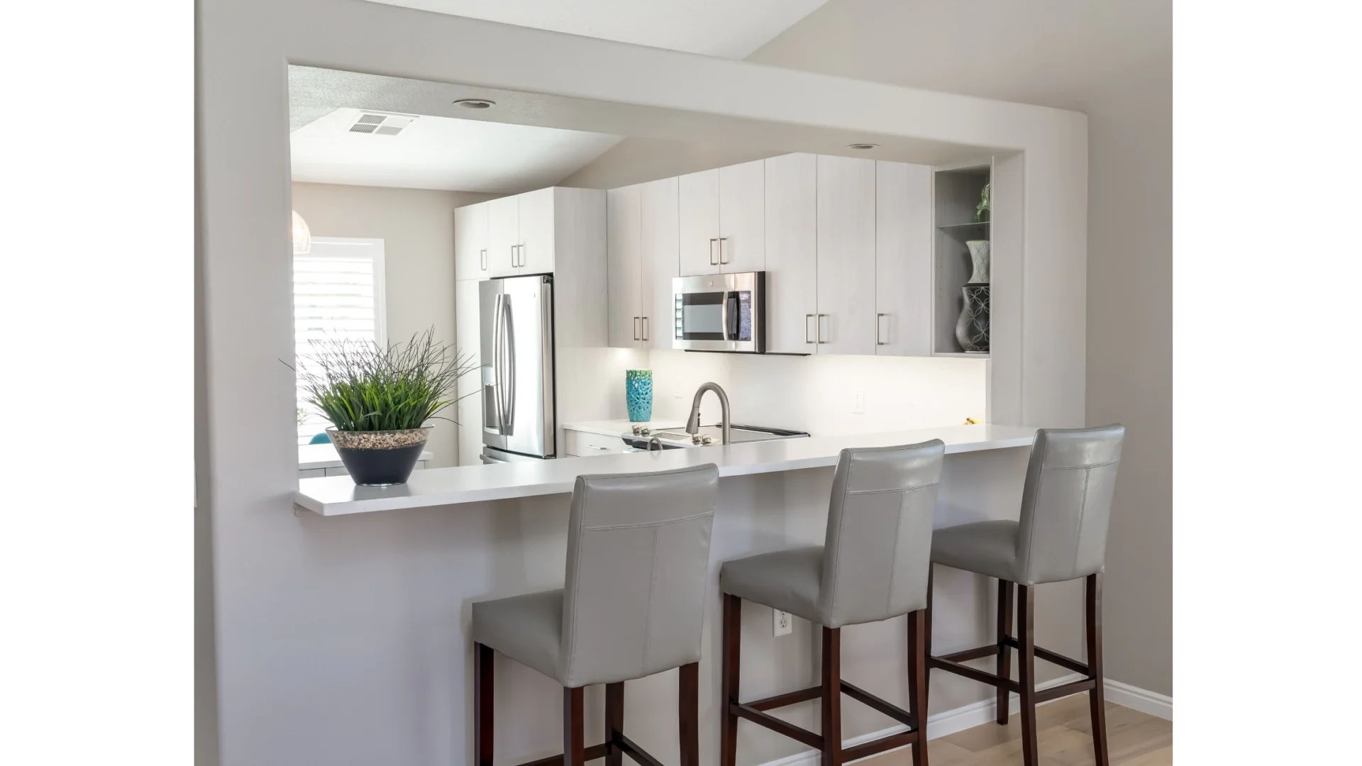 white cabinetry and kitchen room with a white countertop and grey chairs